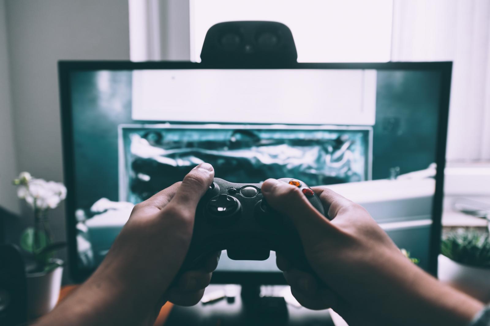 Mani di un ragazzo con un joystick che sta giocando ad un videogioco