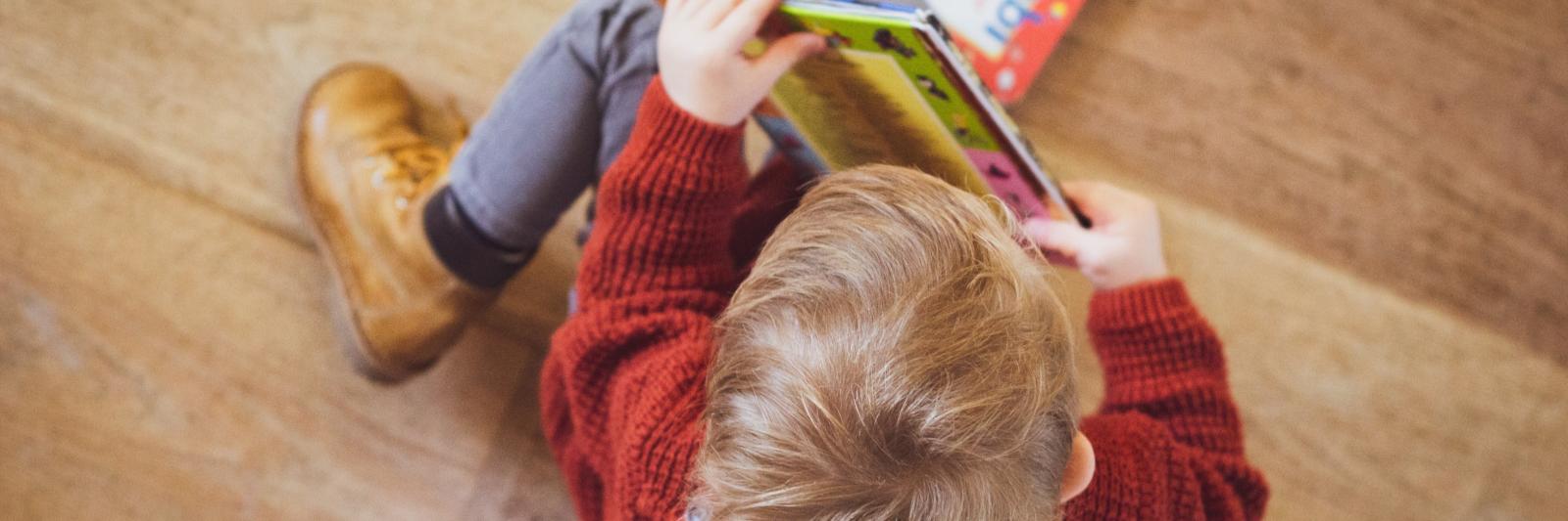 Bambino seduto con un libro in mano