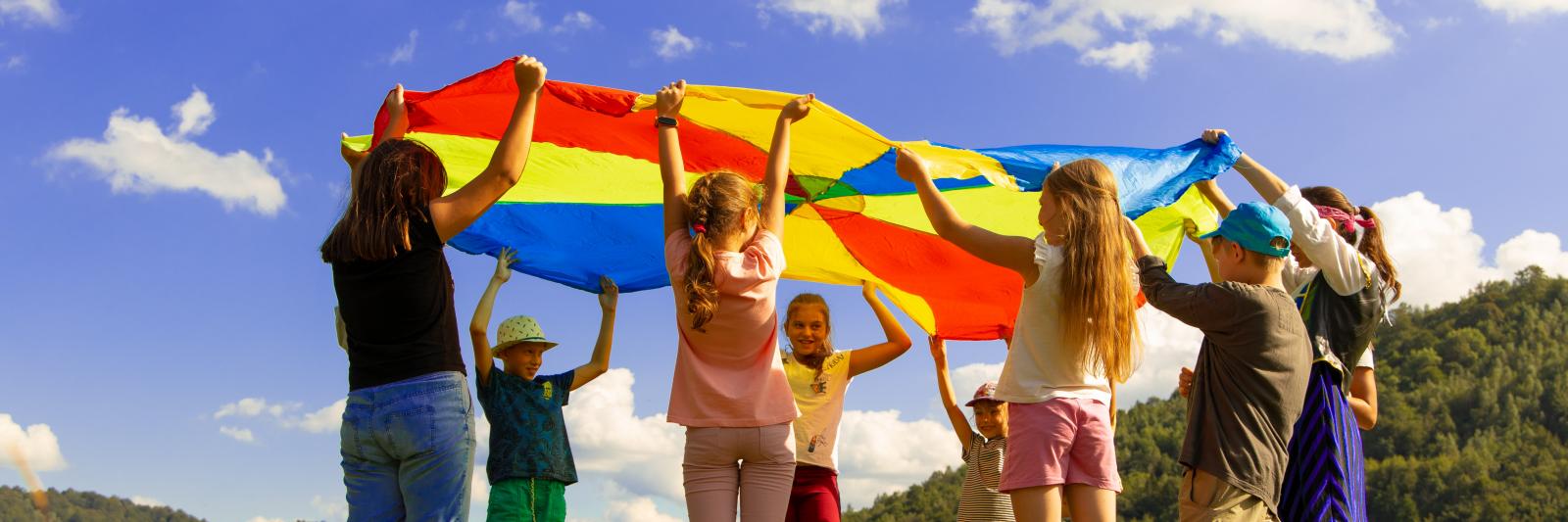 Bambini che giocano con un telo colorato