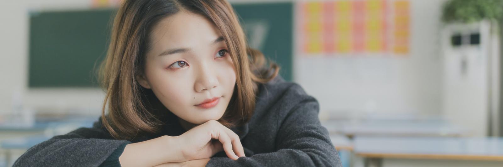 Ragazza con su un libro in un'aula scolastica