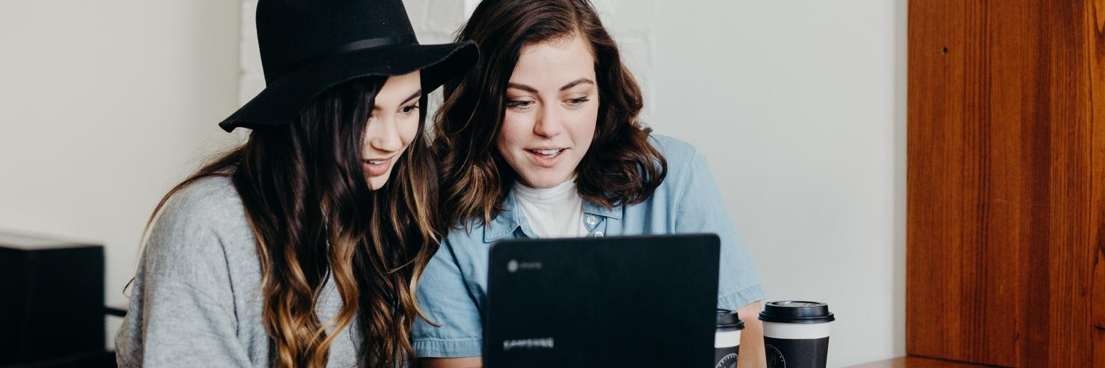 Due ragazze scrivono insieme al computer