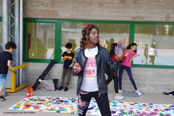 Una ragazza con le mani sporche di vernice colorata