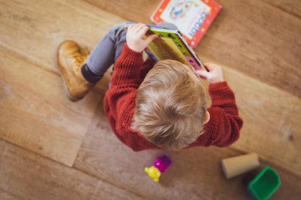 Bambino seduto con un libro in mano