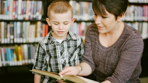 Un'insegnante legge una storia ad un bambino