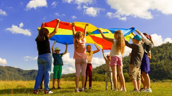 Bambini che giocano con un telo colorato