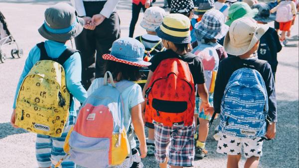 Bambini che camminano con lo zaino di scuola